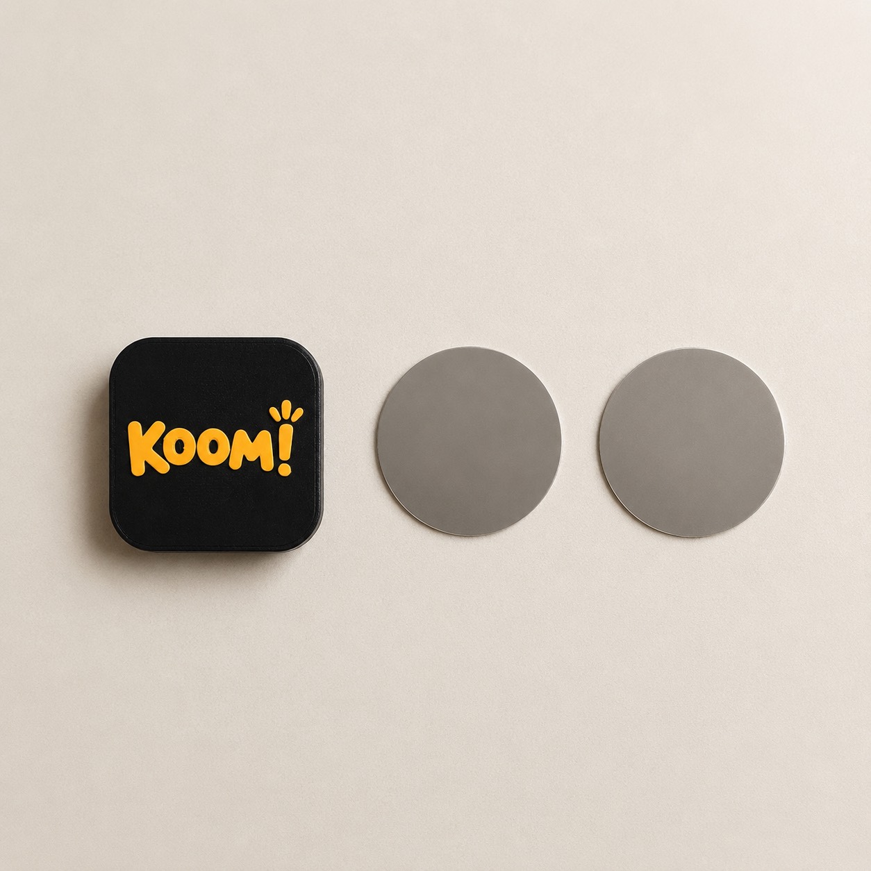 מה מגיע בקופסה: תג Koom! ושתי לוחיות מתכת עגולות להצמדה לקיר